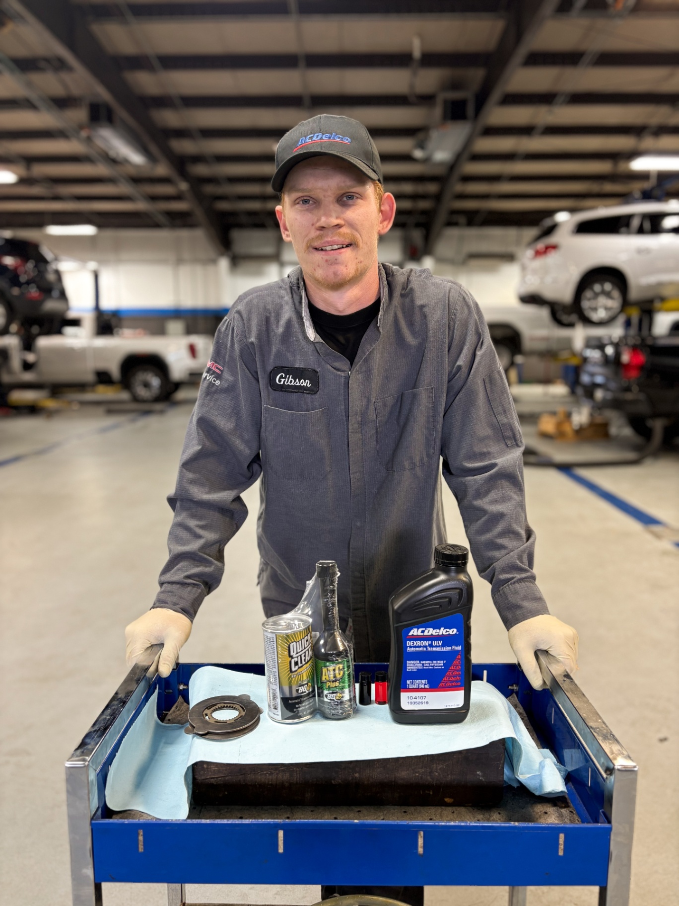Gibson, a Patriot ACDelco technician, presenting a transmission service tray with ACDelco fluid and BG additives