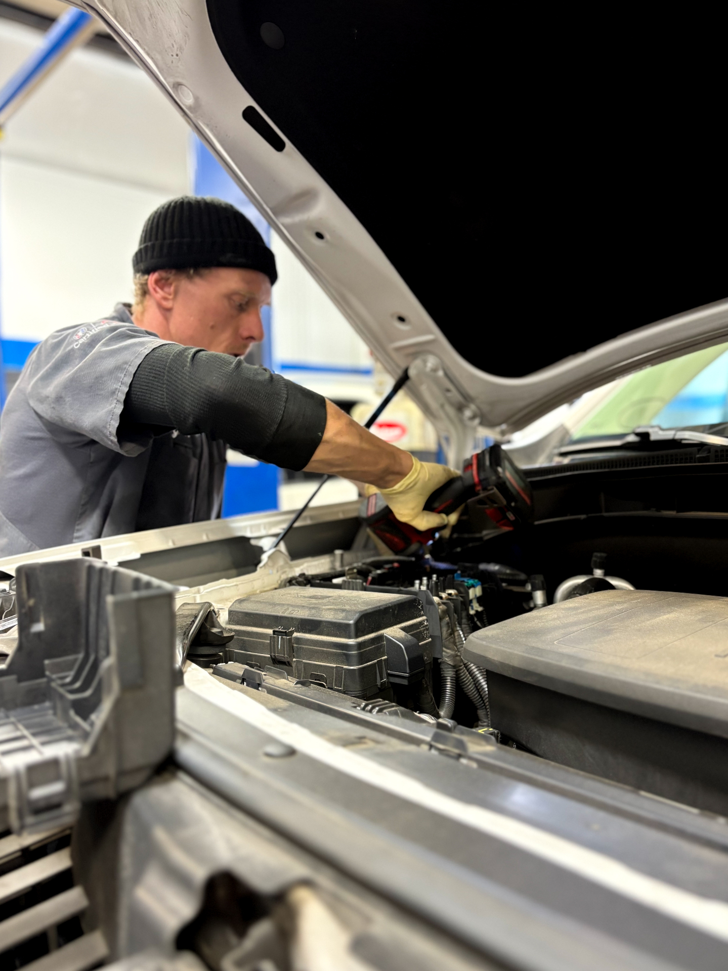 Patriot tech running diagnostics under the hood with a scan tool