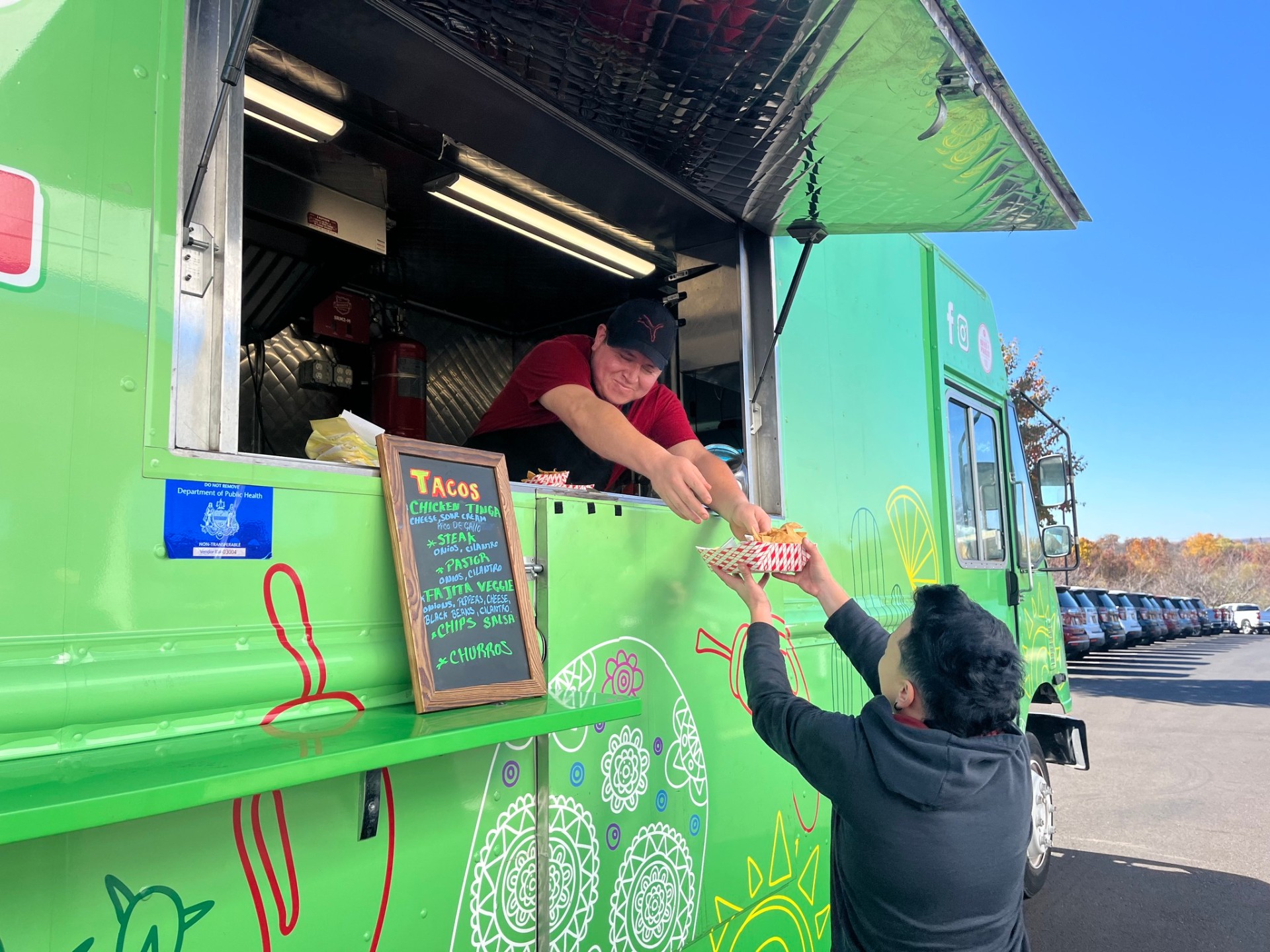 Patriot team member being served fresh tacos from a food truck at the dealership